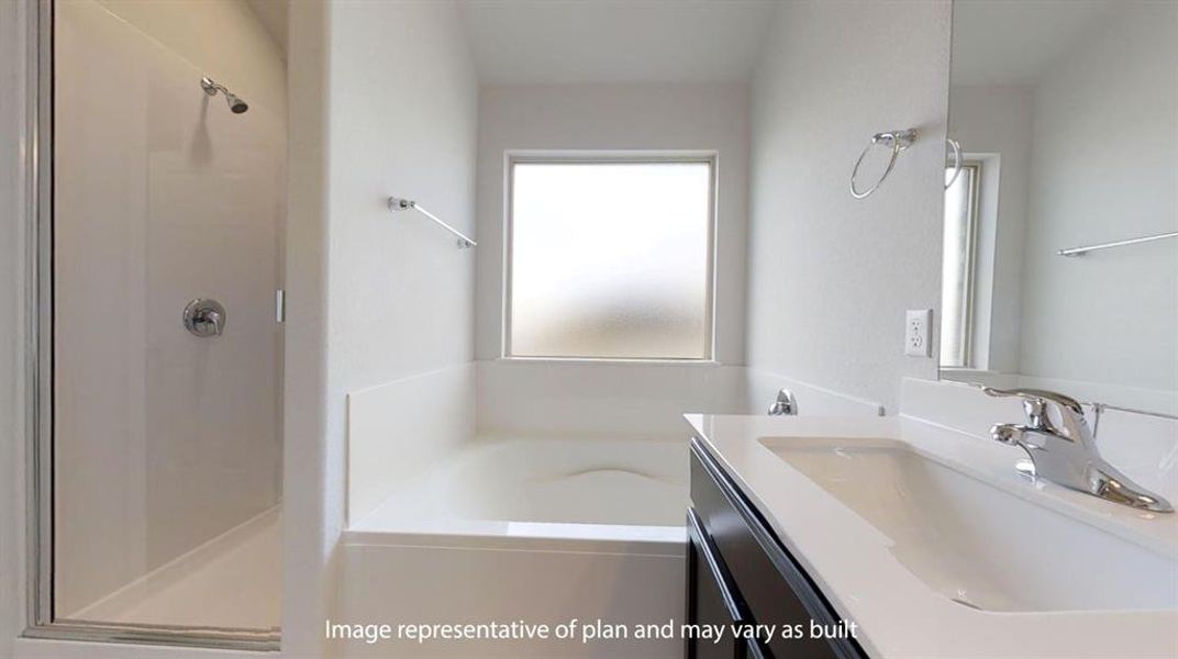 Bathroom featuring a built-in tub with a frosted window, separate shower enclosure with chrome fixtures, a vanity with an integrated sink, and a framed mirror Bathroom featuring a built-in tub with a frosted window, separate shower enclosure with chrome fixtures, a vanity with an integrated sink, and a framed mirror