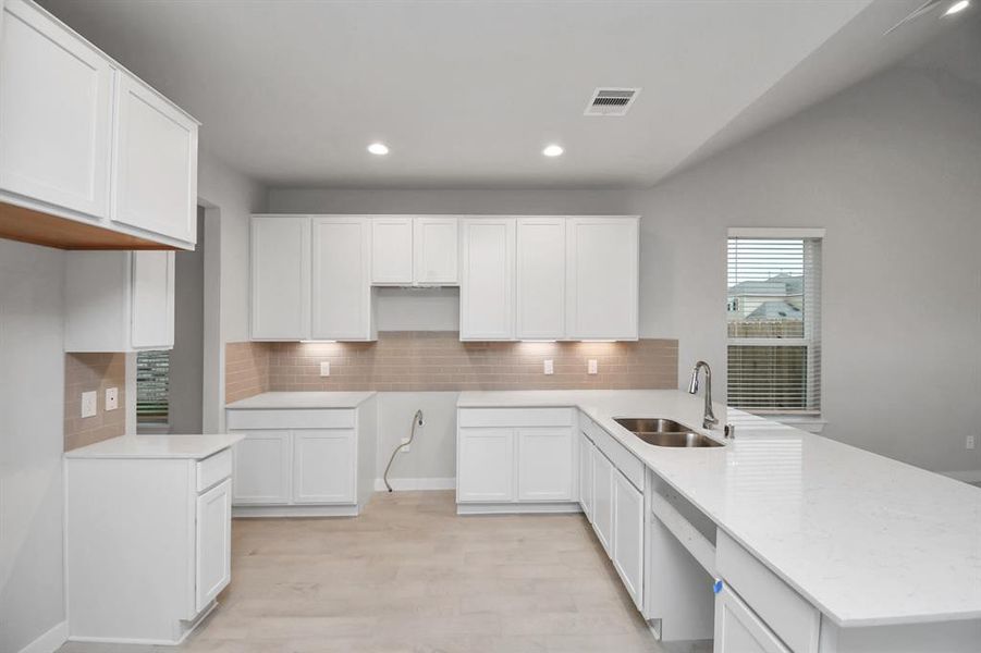 Culinary haven, featuring granite countertops, a tile backsplash, stainless steel appliances (to be installed), and 42” upper cabinets.