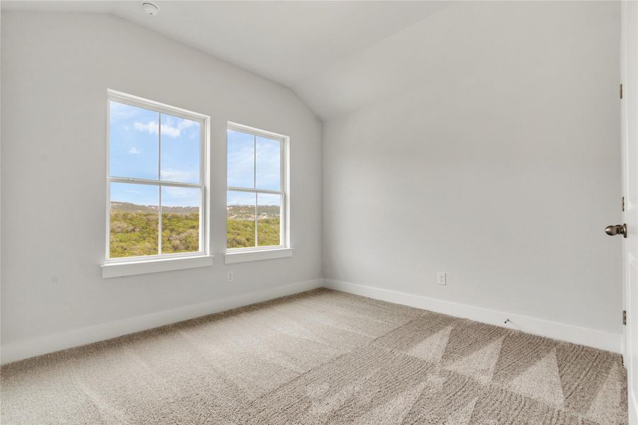 Two large windows provide natural illumination and views of distant green hillsides.