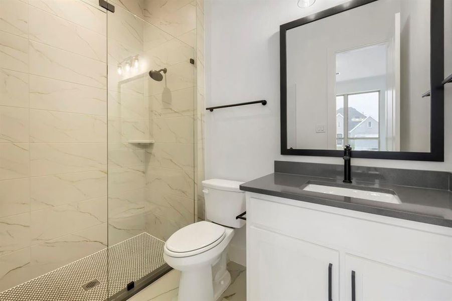 The bathroom features a glass-enclosed shower with tiled walls and a mosaic tile floor