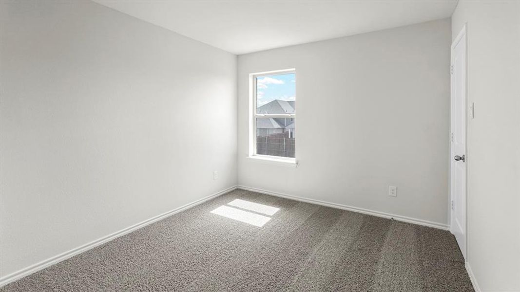 This room features light gray carpeting, neutral white walls, and a window providing natural light