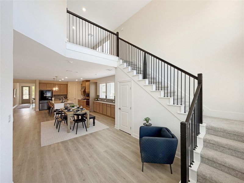 Dining space featuring light wood finished floors, recessed lighting, and a high ceiling