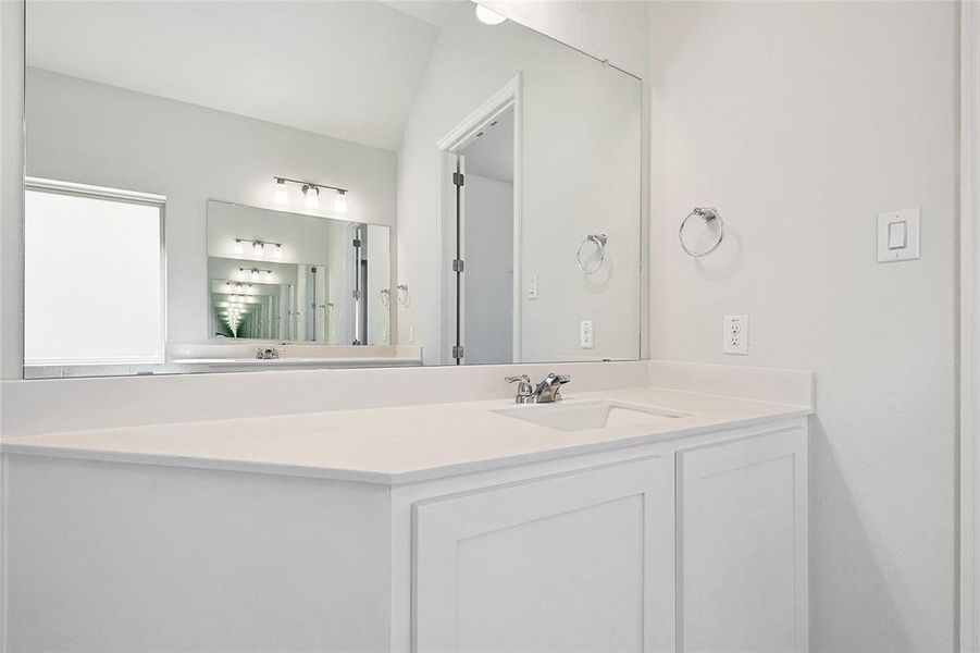 Bathroom with vanity and vaulted ceiling