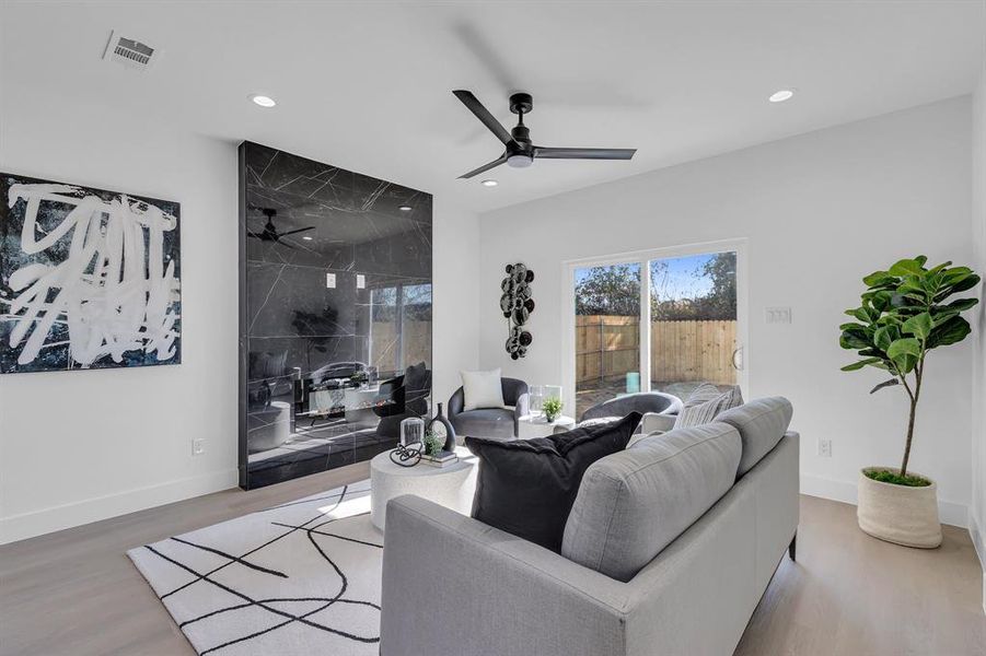 Living room with ceiling fan and hardwood / wood-style flooring