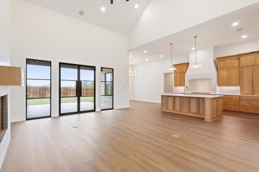 Unfurnished living room featuring light wood finished floors, high vaulted ceiling, recessed lighting, and a fireplace