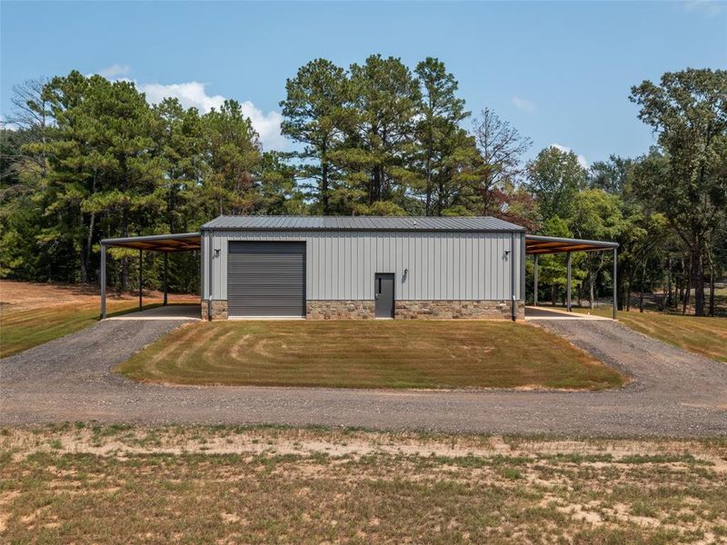 View of outdoor structure with gravel driveway