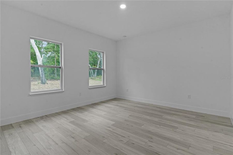 Primary bedroom with windows on the back of the house