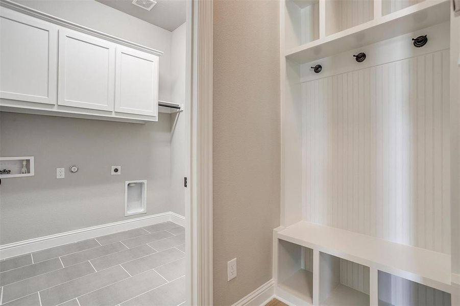 Laundry room featuring washer hookup, light tile patterned flooring, hookup for an electric dryer, gas dryer hookup, and cabinets