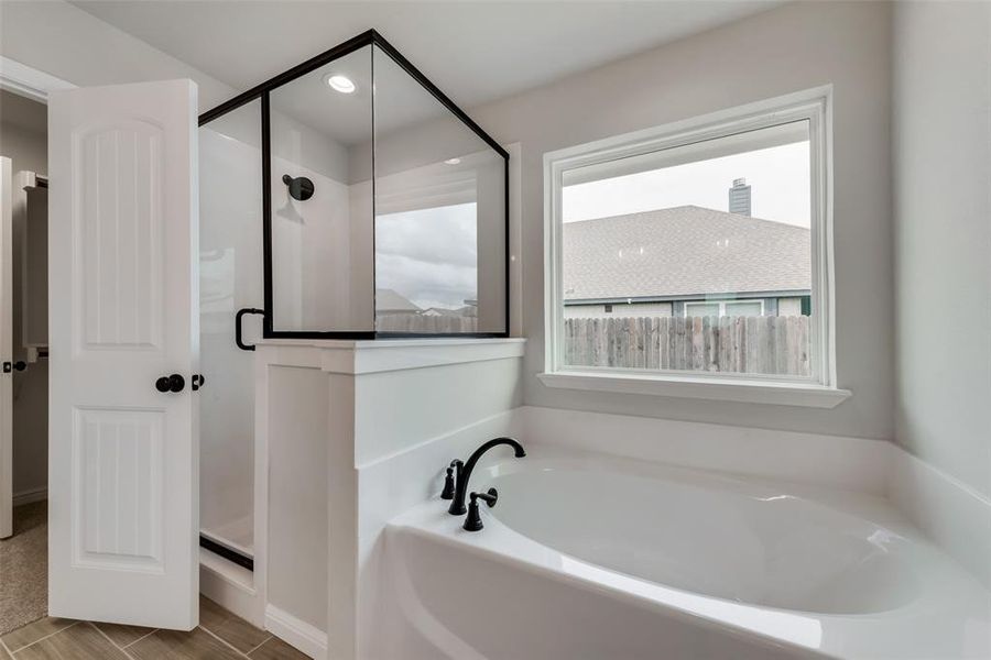 Bathroom featuring shower with separate bathtub and tile patterned floors