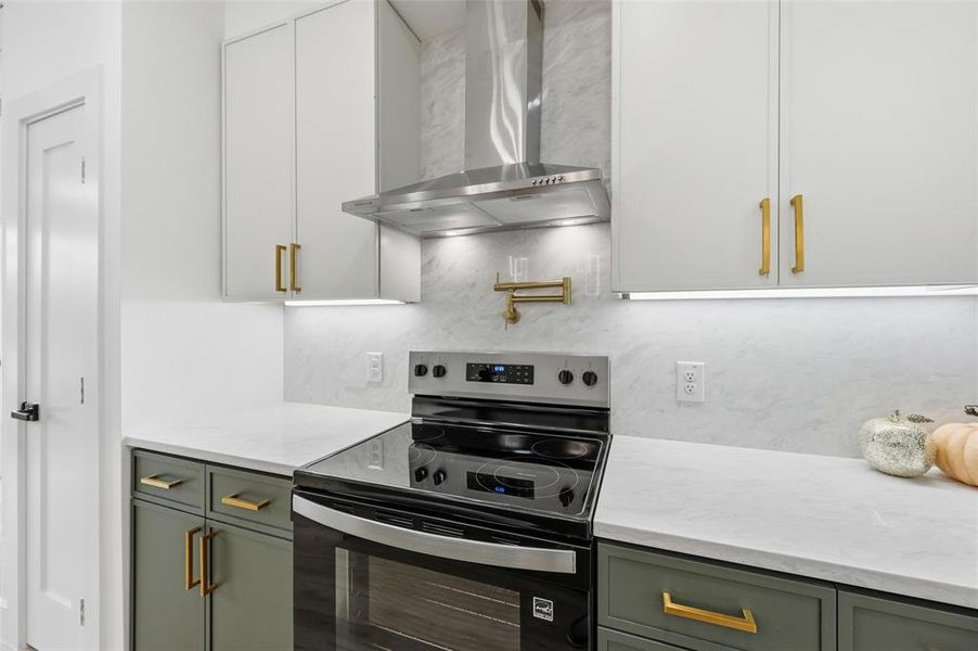 Kitchen featuring stainless steel range with electric stovetop, wall chimney exhaust hood, tons of cabinetry with soft close, and tasteful backsplash Kitchen featuring stainless steel range with electric stovetop, wall chimney exhaust hood, tons of cabinetry with soft close, and tasteful backsplash
