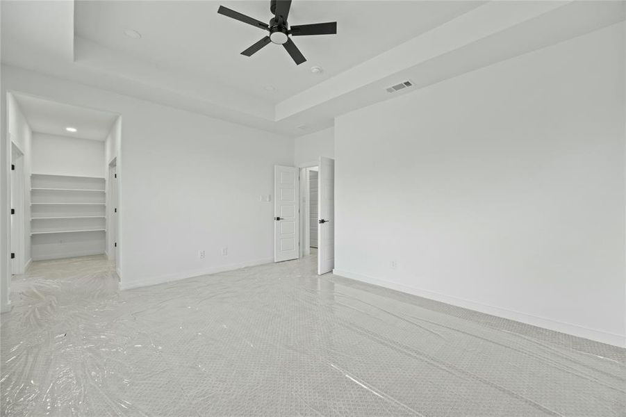 Unfurnished room with a ceiling fan, a tray ceiling, and recessed lighting Unfurnished room with a ceiling fan, a tray ceiling, and recessed lighting