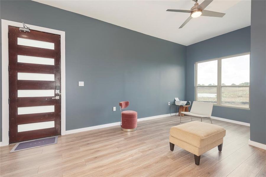 Living area featuring wood finished floors and a ceiling fan Living area featuring wood finished floors and a ceiling fan