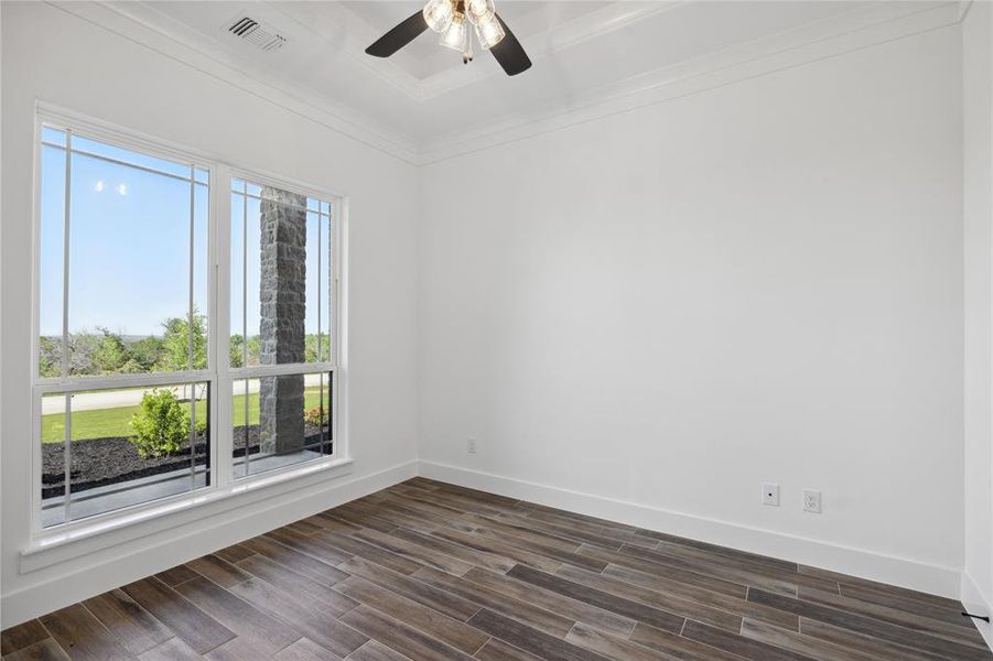 Empty room featuring ceiling fan and dark wood-type flooring