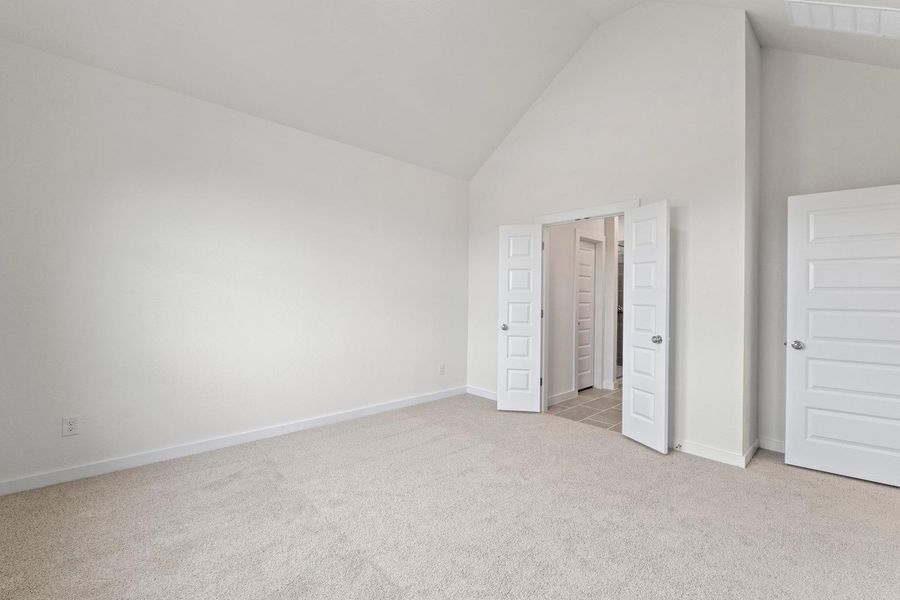 A spacious room features plush carpeting, soaring vaulted ceilings, and a well-lit entrance. A spacious room features plush carpeting, soaring vaulted ceilings, and a well-lit entrance.