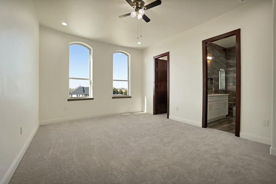 Spare room featuring light colored carpet and ceiling fan