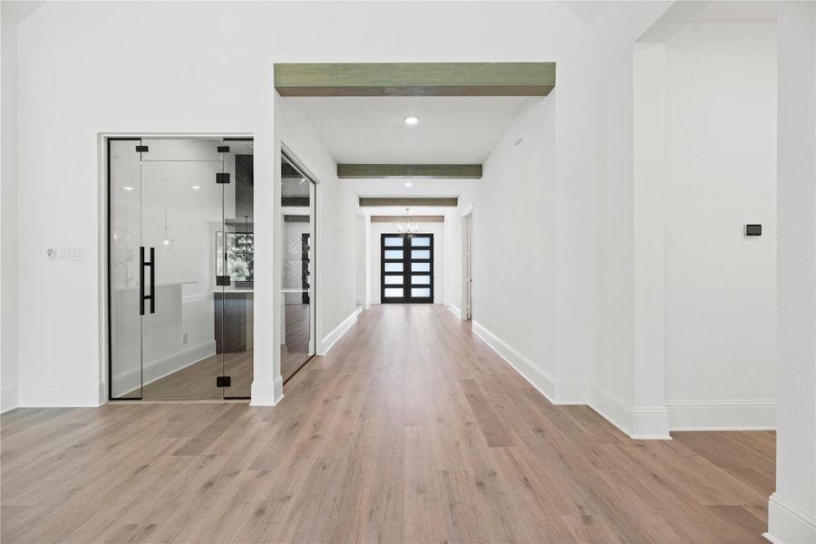 Wide grand hallway adorned with wood beams welcomes you into the home.