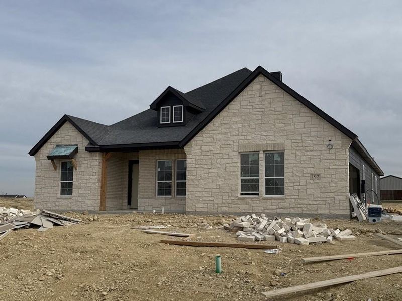 View of front of property featuring stone siding and a shingled roof
