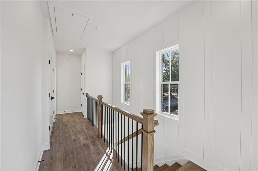 Primary bedroom and secondary bedroom located on 3rd floor with hard surface hallways, hard wood stairs and upstairs laundry closet, attic access, recessed lighting.  Image is of a previously built Chamberlain.