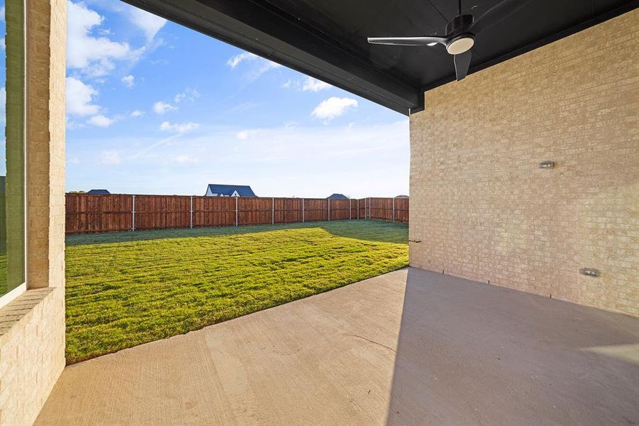 Fenced backyard with ceiling fan and a patio area Fenced backyard with ceiling fan and a patio area