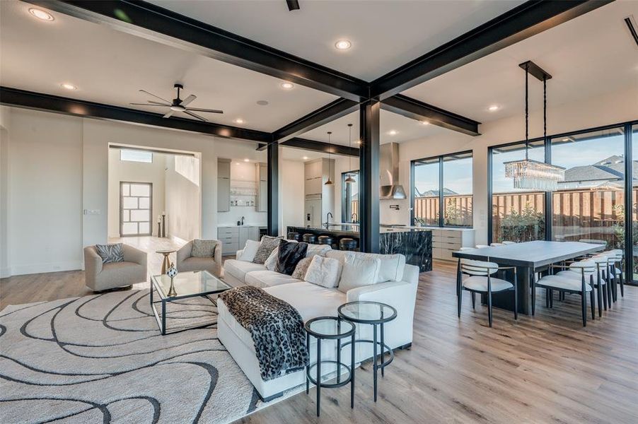 Living room with beam ceiling, ceiling fan, and light hardwood / wood-style flooring