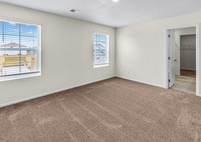 Spacious master bedroom with windows and an attached bathroom.