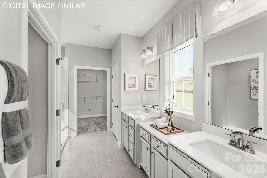Bright primary bath with dual vanities, walk-in shower, and a spacious walk-in closet for everyday ease. Bright primary bath with dual vanities, walk-in shower, and a spacious walk-in closet for everyday ease.