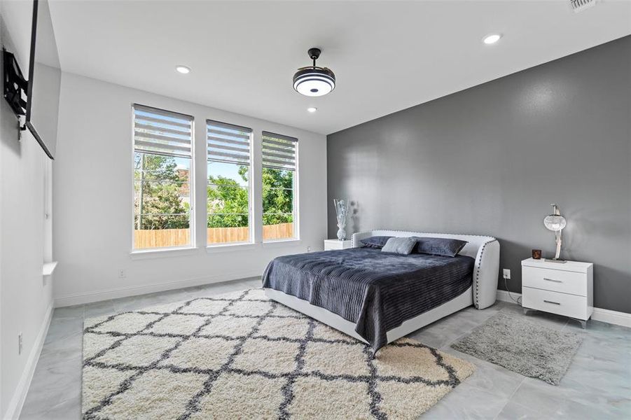 Spacious room featuring three large windows, recessed lighting, and a modern ceiling fan