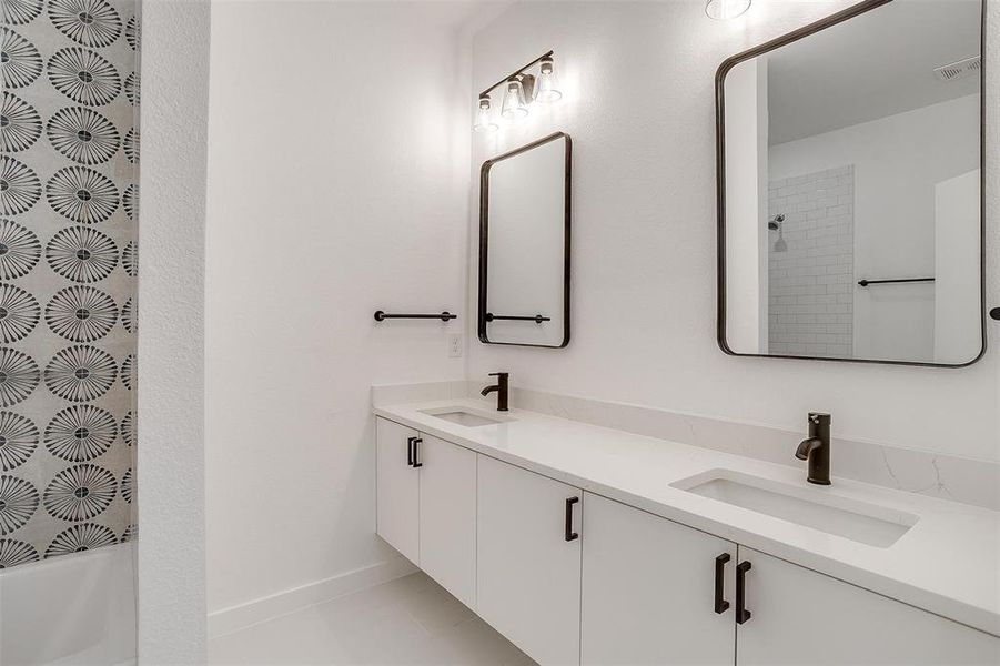 Bathroom with vanity, tile patterned flooring, and shower / tub combination Bathroom with vanity, tile patterned flooring, and shower / tub combination