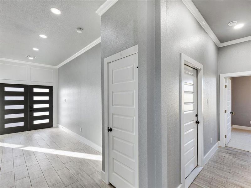 Entryway featuring crown molding, wood finish floors, and recessed lighting Entryway featuring crown molding, wood finish floors, and recessed lighting