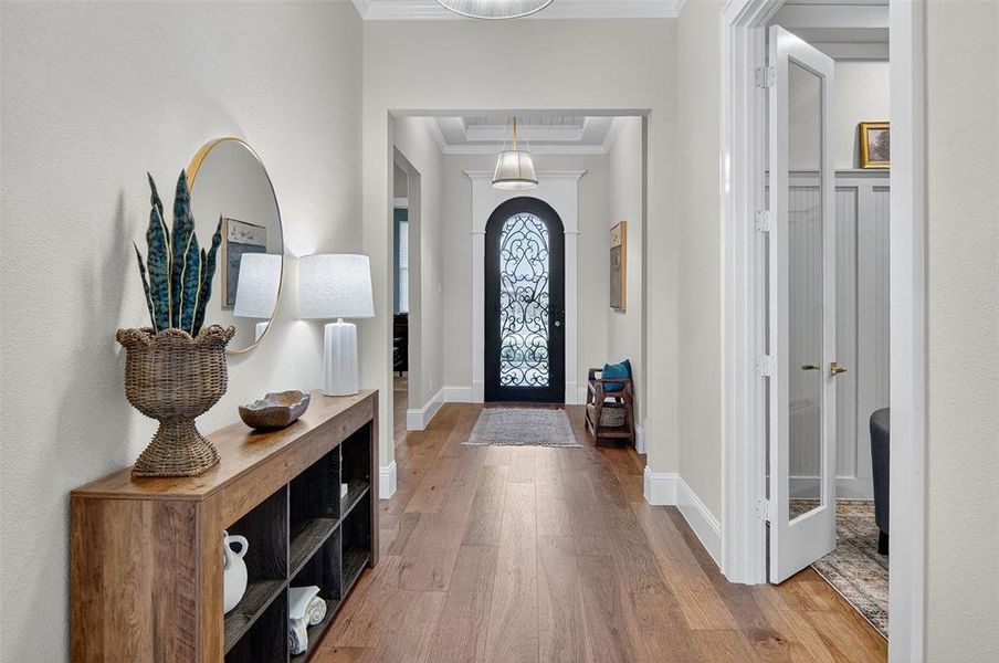 Entryway featuring light wood-style flooring and ornamental molding