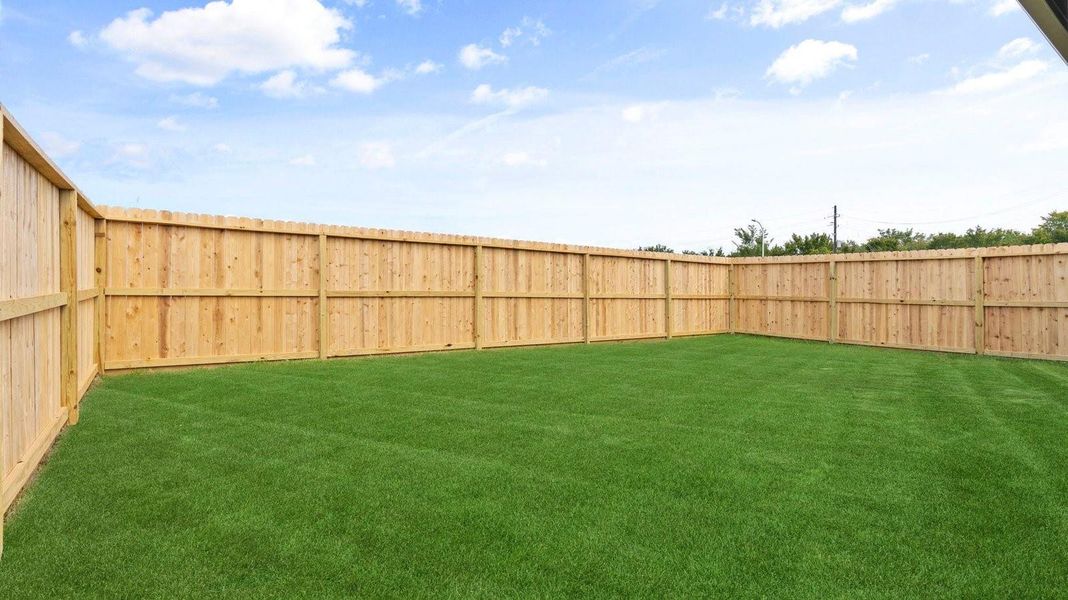 Large fenced-in backyard with a covered patio, perfect for outdoor entertaining.