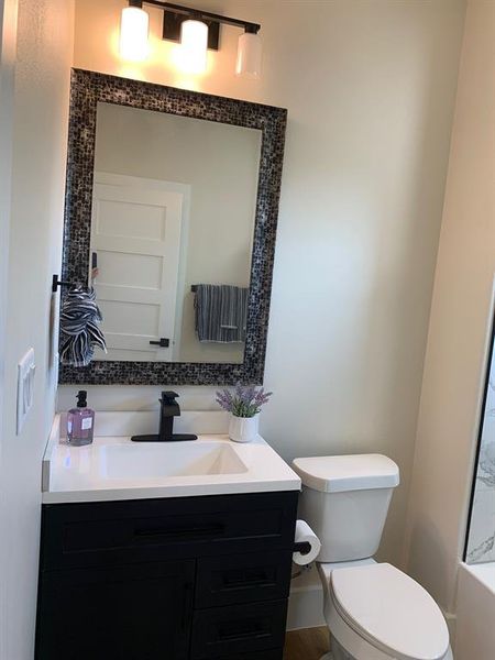 Bathroom featuring vanity, flooring, and toilet