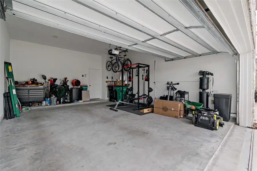 Spacious two-car garage with ample storage, workout equipment, and room for tools and outdoor gear. Spacious two-car garage with ample storage, workout equipment, and room for tools and outdoor gear.