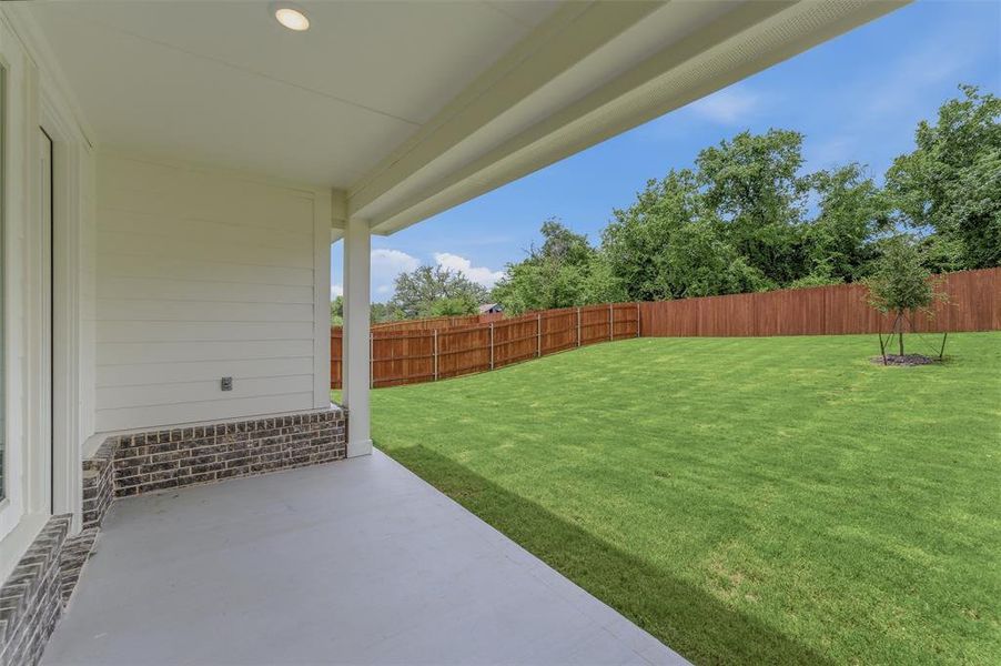 Spacious covered patio with recessed lighting and a concrete surface