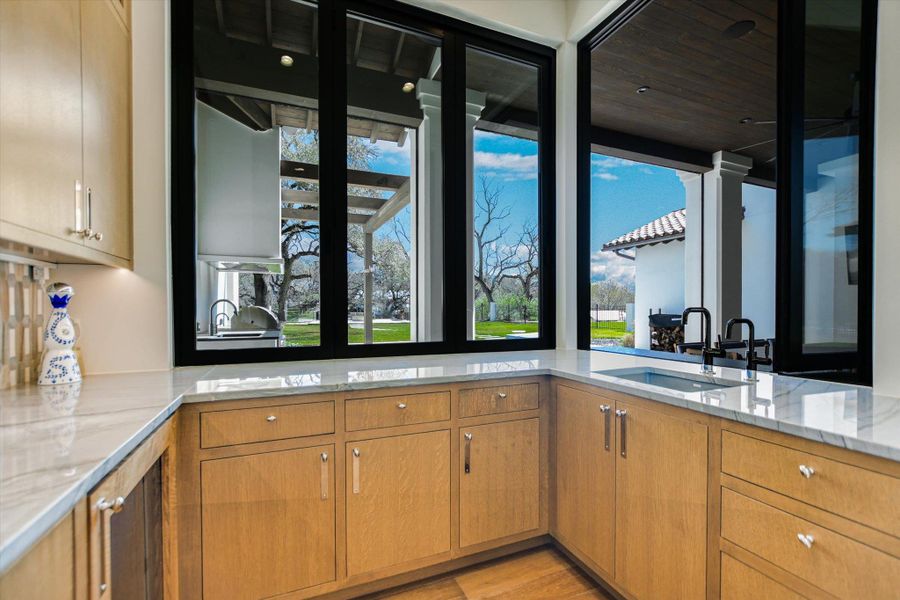 Kitchen featuring light stone countertops, healthy amount of natural light, and light wood finished floors
