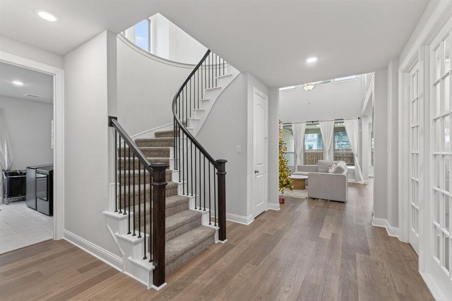 Foyer entrance featuring light wood finished floors, stairway, recessed lighting, and washer / dryer Foyer entrance featuring light wood finished floors, stairway, recessed lighting, and washer / dryer
