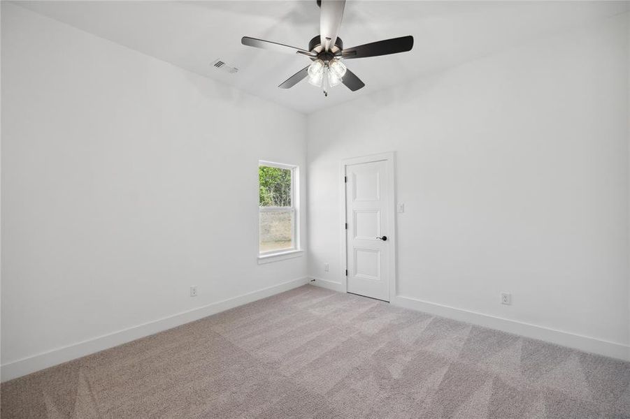 Empty room featuring light carpet and ceiling fan