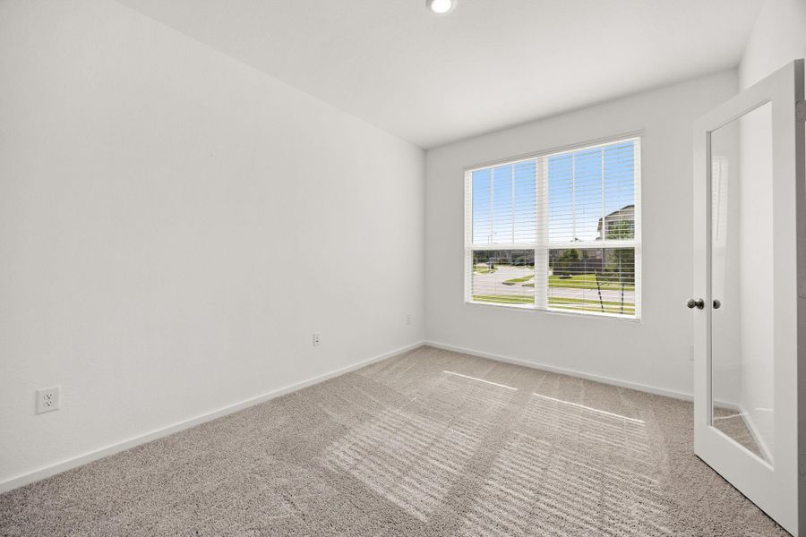 The downstairs secondary bedroom offers incredible flexibility with generous square footage, making it ideal as a guest room, home office, playroom, or fifth bedroom. Complete with French doors and a massive walk-in closet, this versatile space adapts to your needs.