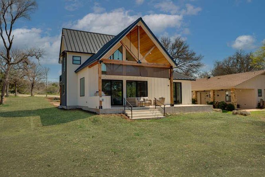 Back of house with a metal roof, a yard, a patio area, and a standing seam roof