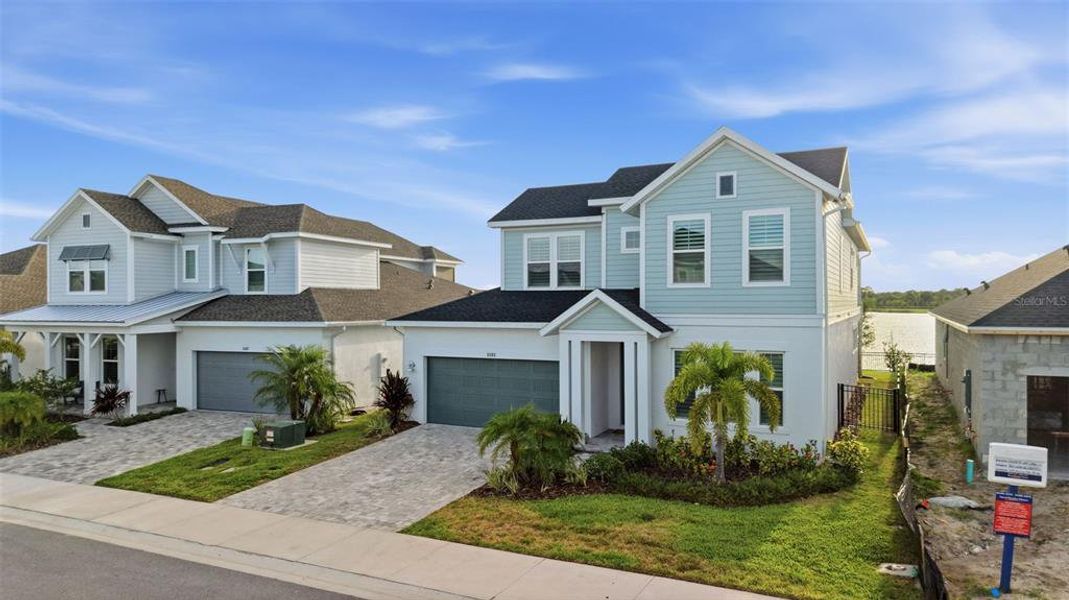Front exterior of a new home in Emerald Landing at Waterside at Lakewood Ranch – Lake Series, Sarasota, FL, highlighting curb appeal (Image 25). Front exterior of a new home in Emerald Landing at Waterside at Lakewood Ranch – Lake Series, Sarasota, FL, highlighting curb appeal (Image 25).