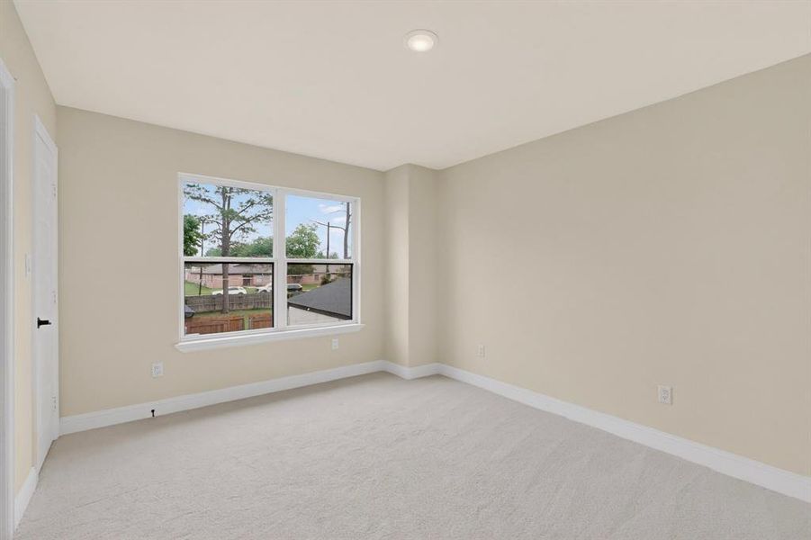 Neutral-toned interior room featuring light beige walls and light gray carpeting