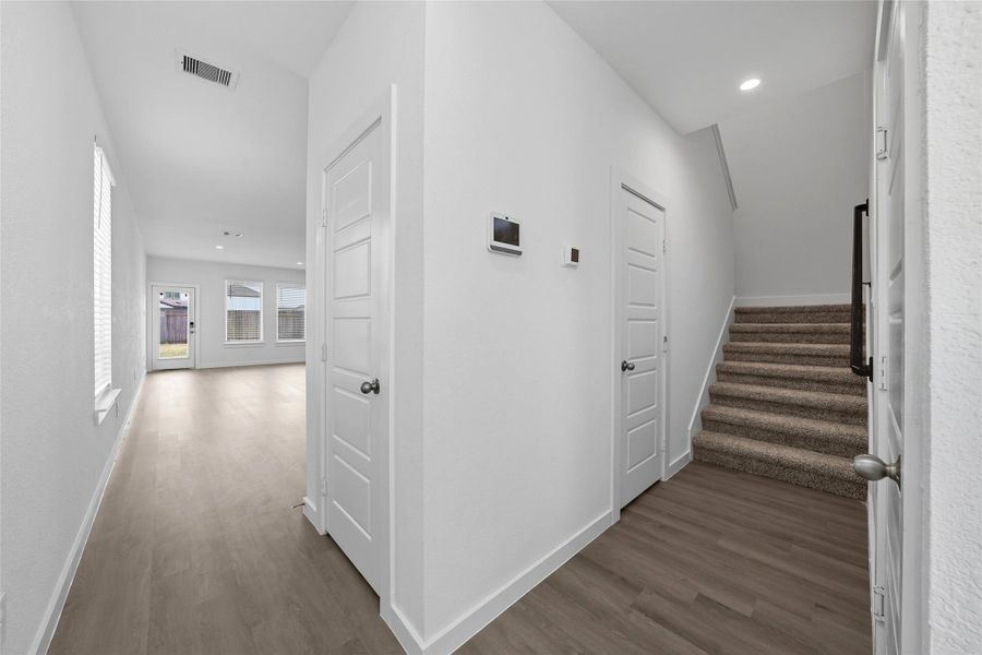 Bright entryway with wood-style flooring lead into the main living space. The carpeted staircase to the second level add comfort and warmth.