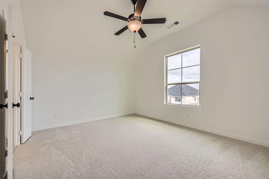 Spare room with vaulted ceiling, light carpet, and a ceiling fan Spare room with vaulted ceiling, light carpet, and a ceiling fan
