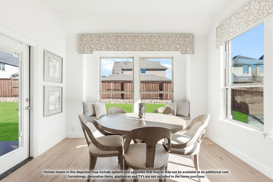 Bright breakfast nook with round dining table, window bench seat, and light hardwood floors Bright breakfast nook with round dining table, window bench seat, and light hardwood floors