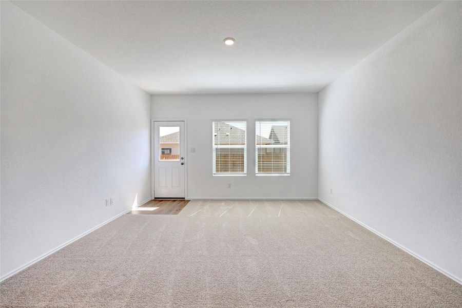 Spare room featuring light carpet and baseboards