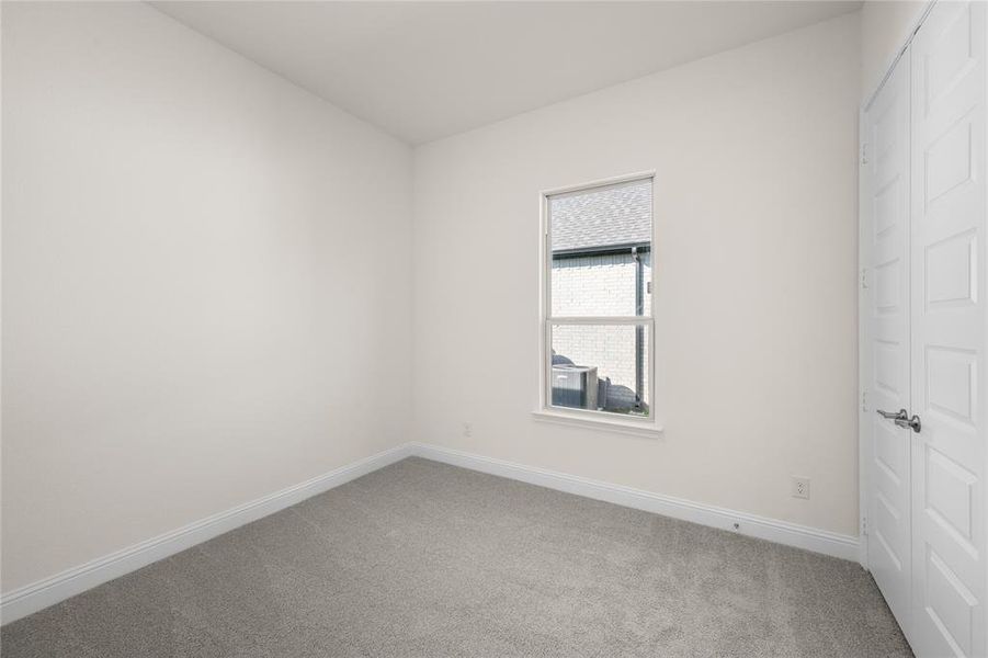 Carpeted spare room with baseboards