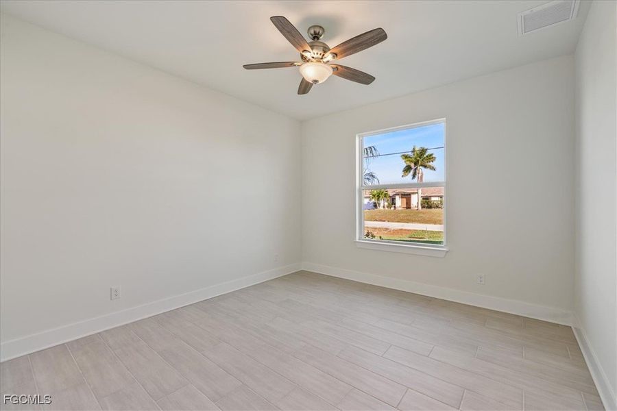 Empty room with wood finish floors and ceiling fan
