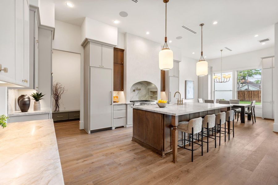 This expansive kitchen showcases a thoughtful layout with extensive cabinetry, generous counter space, and a large island designed for gathering. Seamless flow into the breakfast area enhances both everyday living and entertaining.