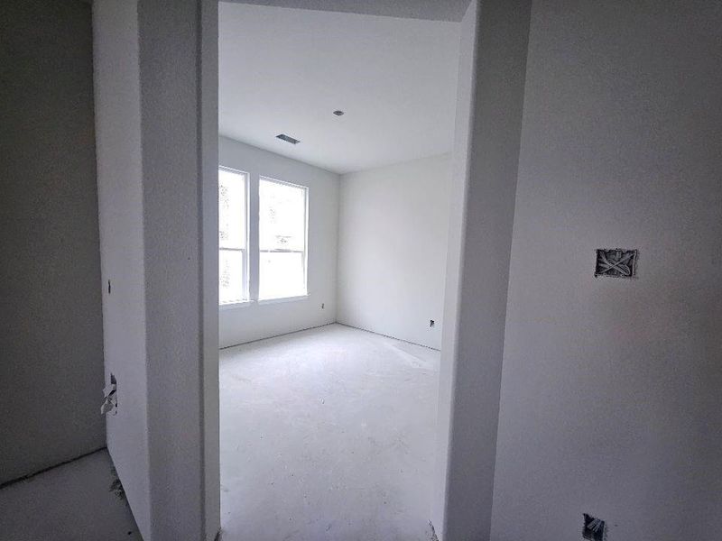 Unfinished interior room with two large windows, white walls, and a recessed ceiling vent Unfinished interior room with two large windows, white walls, and a recessed ceiling vent
