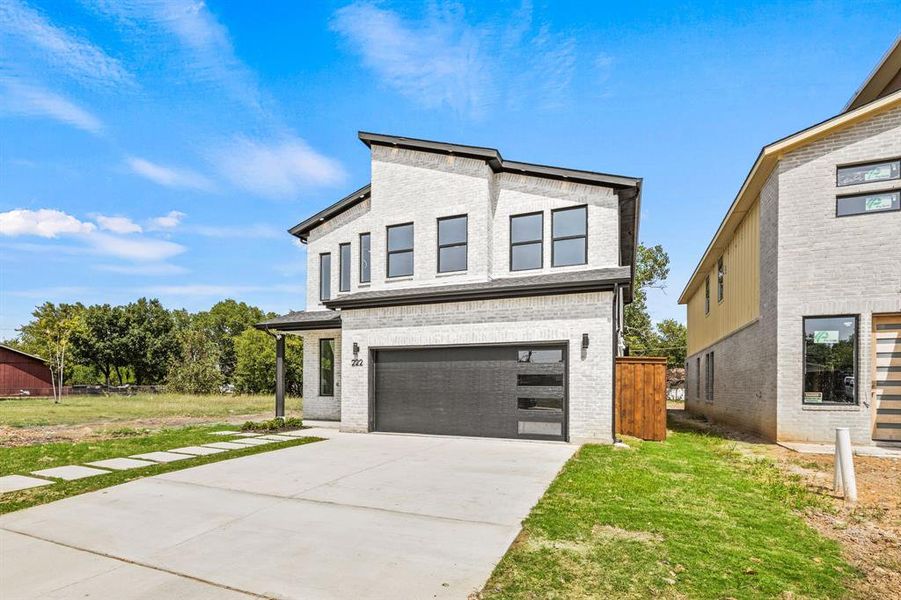 View of front facade with a garage and a front lawn